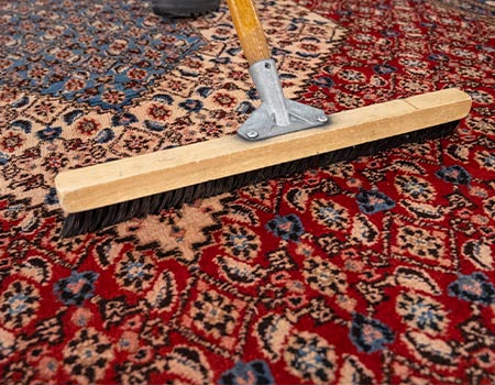 Professional worker cleaning oriental rug